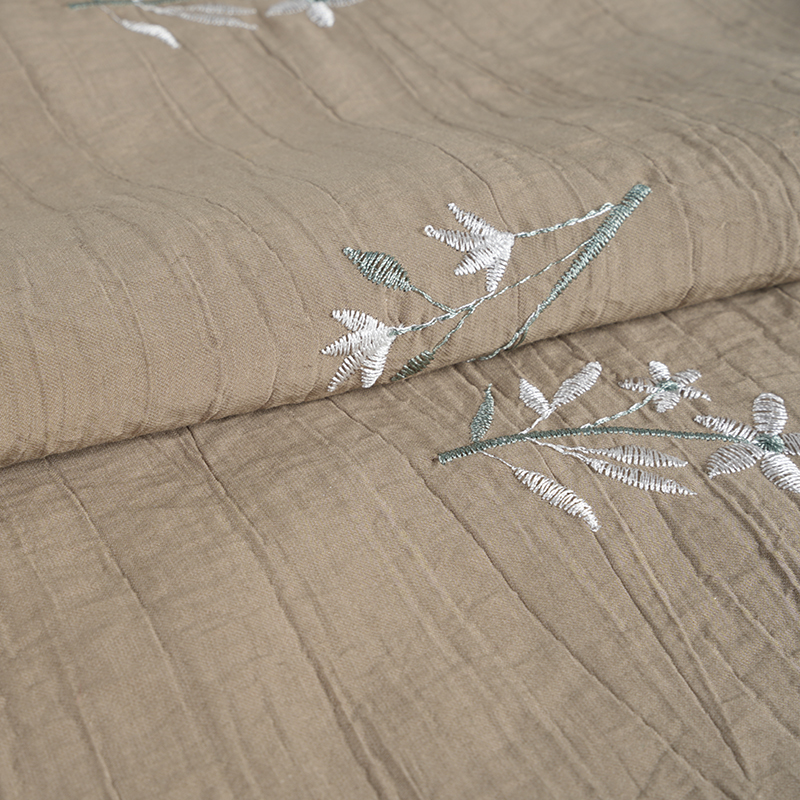 Tissu froissé de fleurs brodées d'orchidées et de graines de pêche